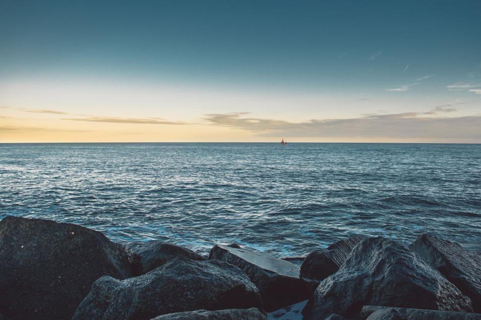 Free Image of Serene ocean horizon with small distant sailboat 