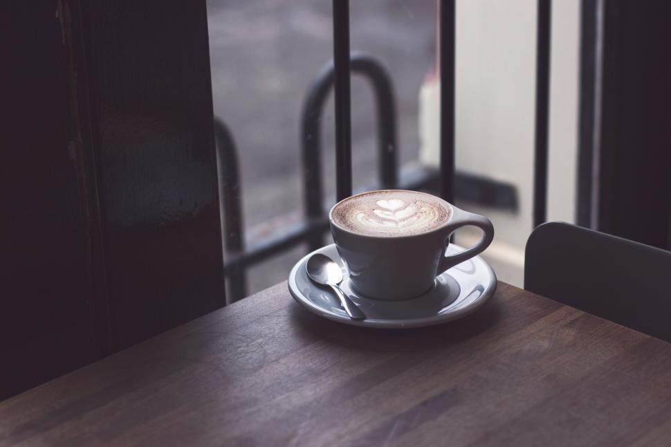 Free Image of Artful latte on a rustic coffee shop table 