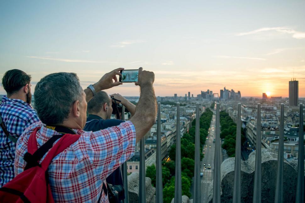 Free Image of Tourists capturing sunset in cityscape 