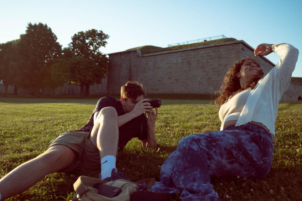 Free Image of Couple photographing in open green space 