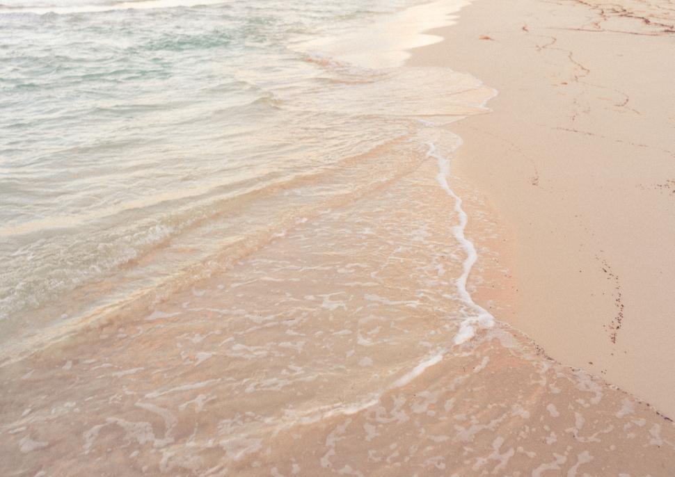 Free Image of Gentle waves washing over sandy beach 