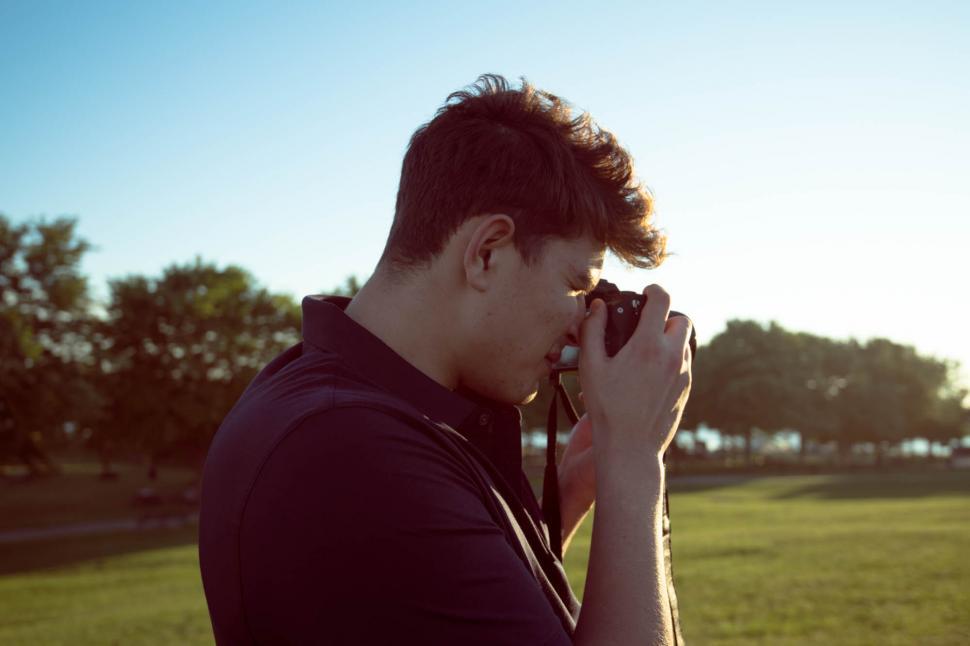 Free Image of Young man with camera capturing moments at sunset 