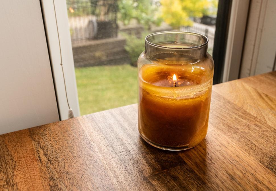 Free Image of Burning scented candle on wooden table 