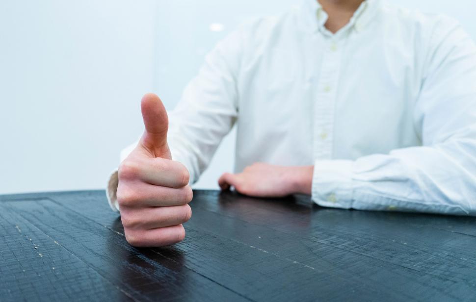 Free Image of Close-up of a thumbs-up gesture on a table 