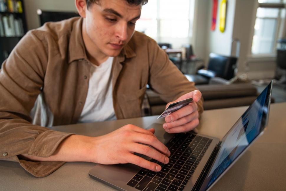 Free Image of Man multitasking with phone and laptop 