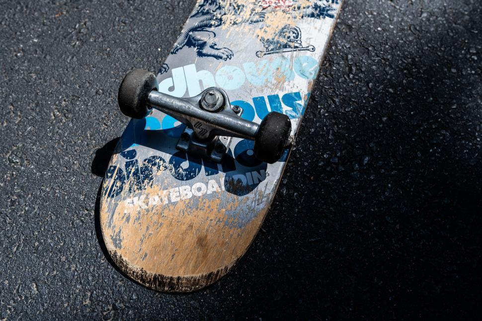 Free Image of Worn skateboard on asphalt texture 