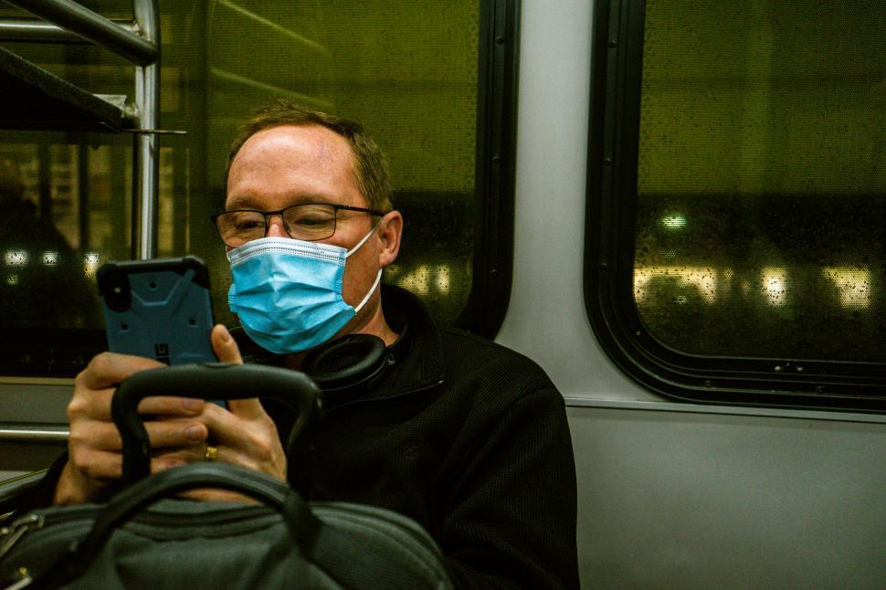 Free Image of Man using smartphone on train 