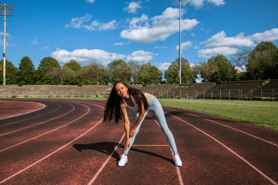 Free Image of Woman doing stretching on track 