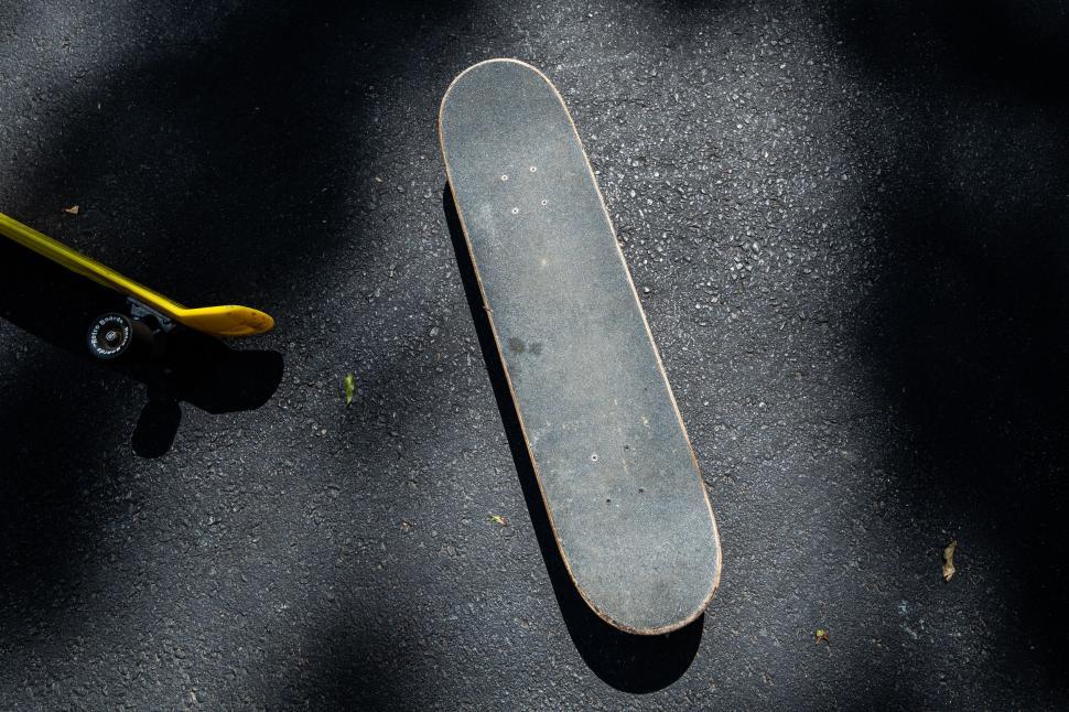 Free Image of Skateboard in shadow on concrete ground 