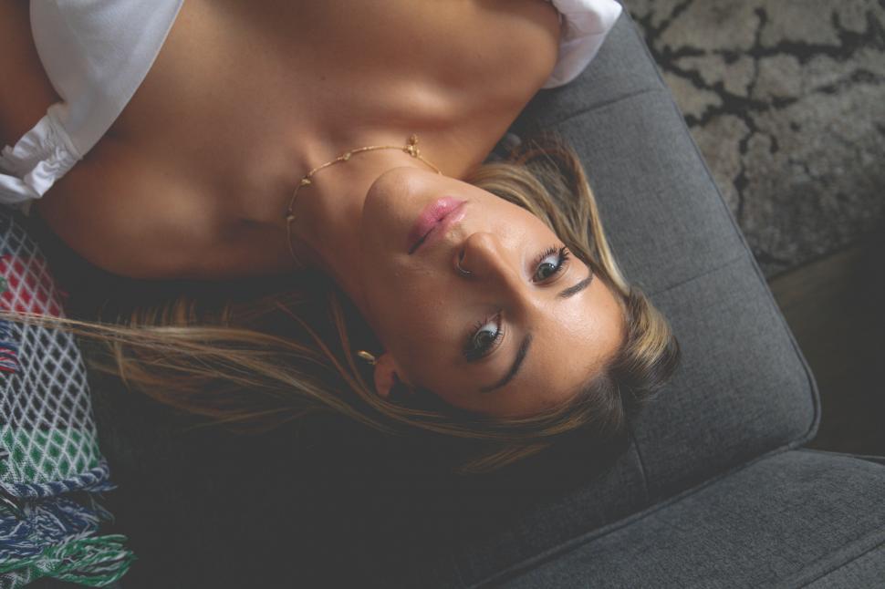 Free Image of Woman relaxing on a couch with body chain jewelry 