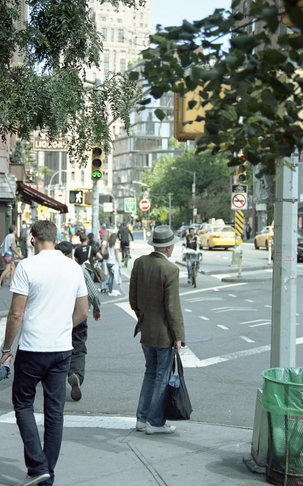 Free Image of Man walking in the city with bag over shoulder 
