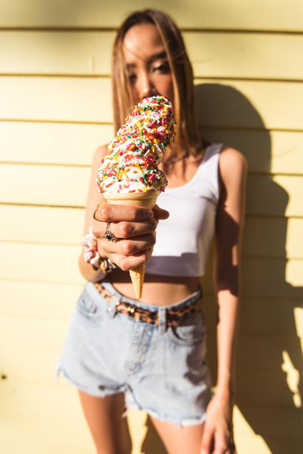 Free Image of Woman holding a colorful ice cream cone 