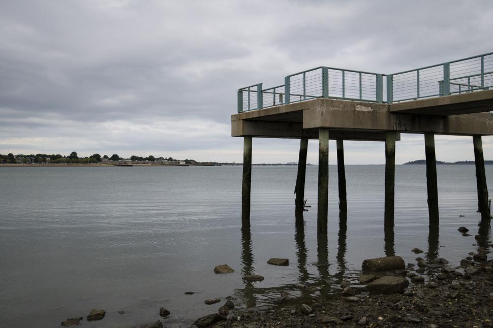 Free Image of Seaside pier extending into calm waters 