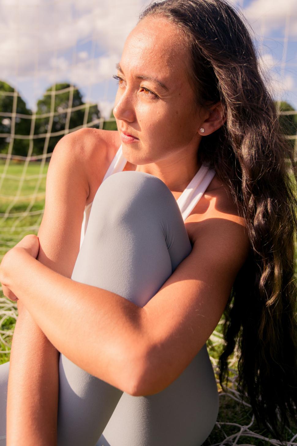 Free Image of Woman in a swimsuit against a sports net 