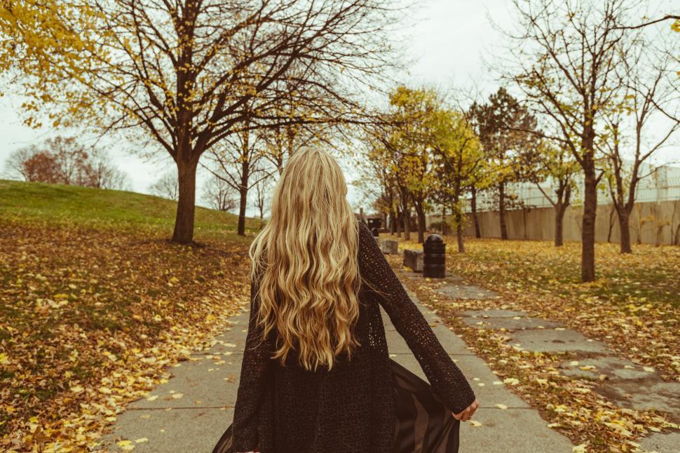 Free Image of Blonde woman walking through autumn park 