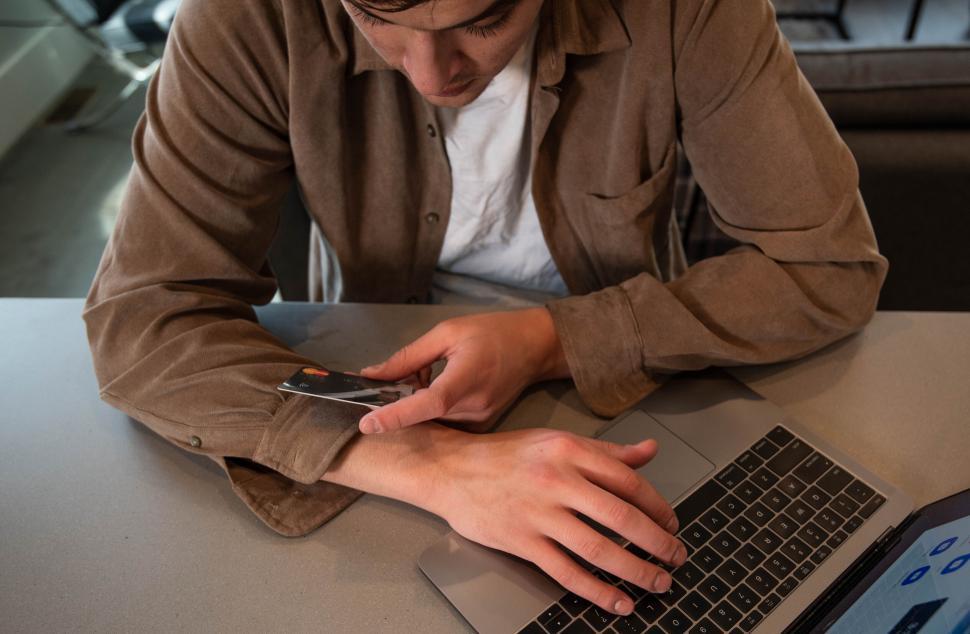 Free Image of Man working on laptop with credit card 