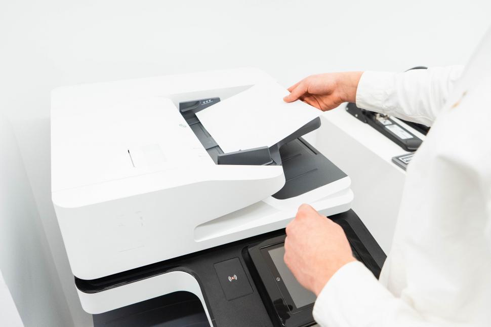 Free Image of Person using a modern printer at office 