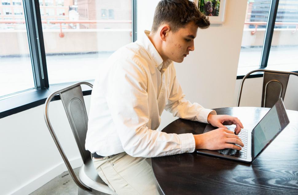 Free Image of Man working on a laptop at a table 