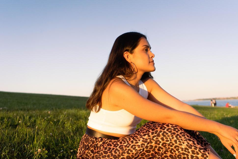 Free Image of Girl sitting on a green grass hill 