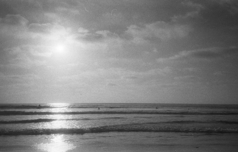 Free Image of Black and white beach with sun reflection 