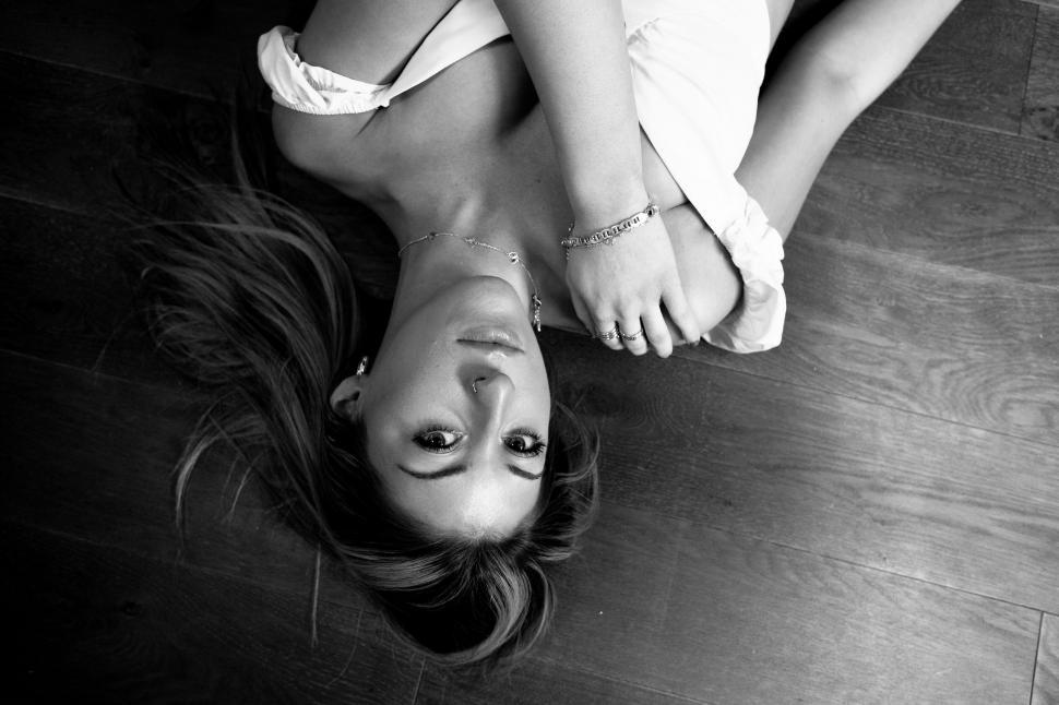 Free Image of Woman lying on floor in artistic pose 