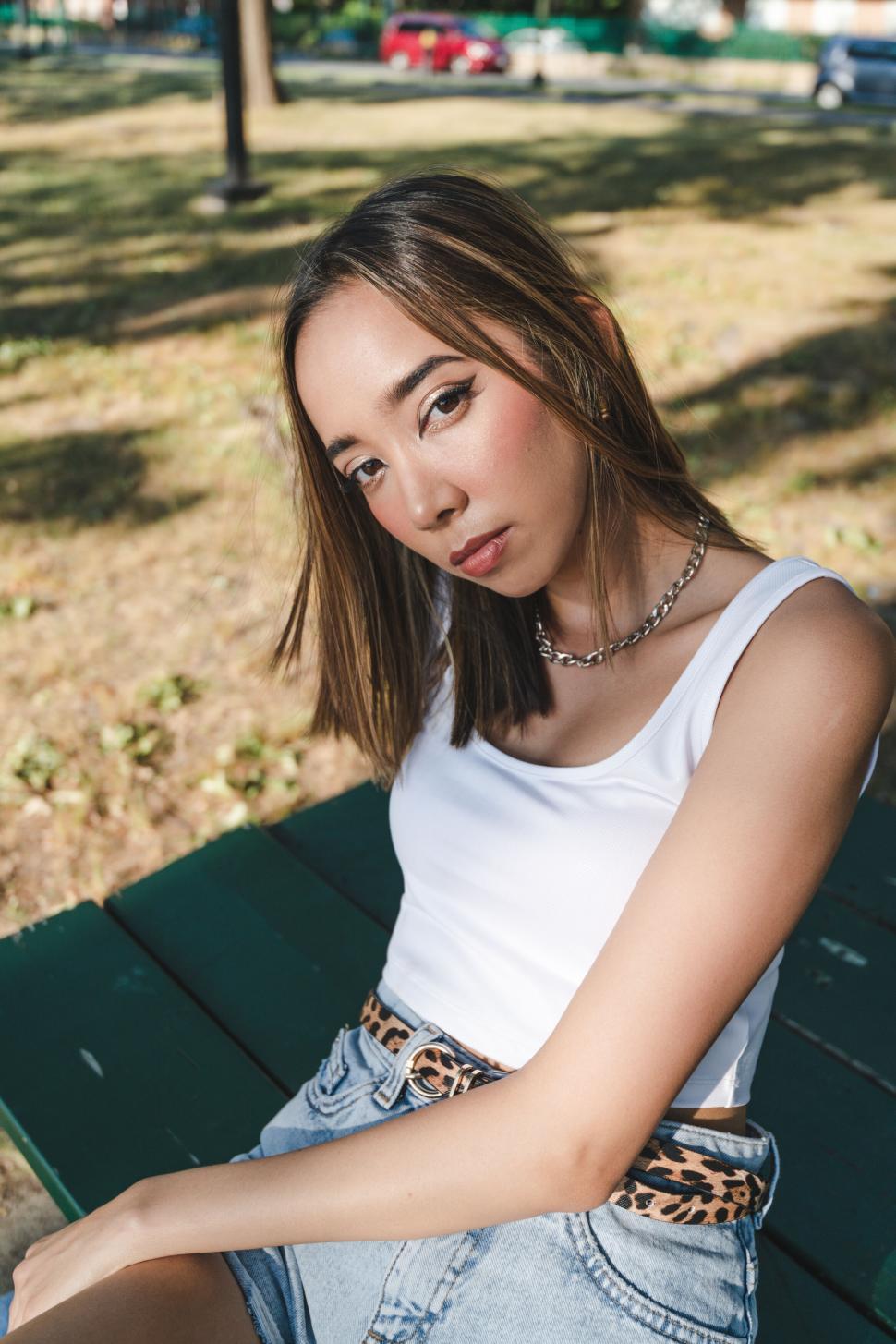 Free Image of Young woman sitting on park bench 