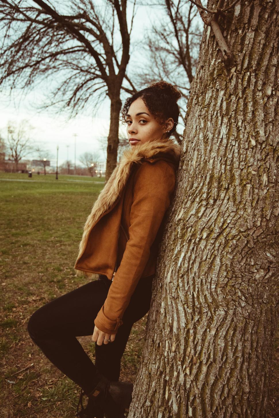 Free Image of Woman Leaning on a Tree in Fall 