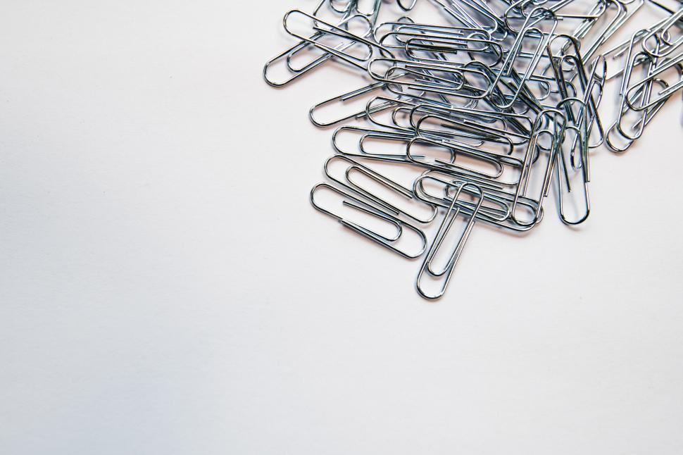 Free Image of Scattered metal paperclips on white 