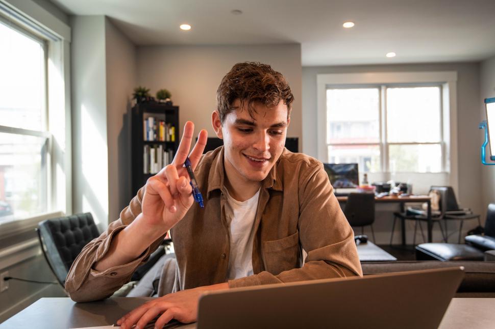 Free Image of Man giving peace sign while working 
