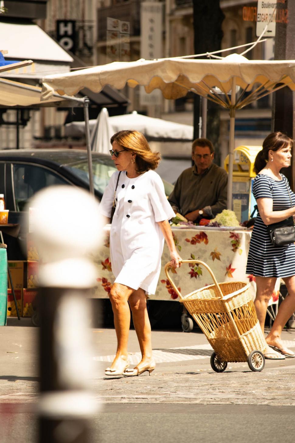 Free Image of Woman in white dress walking in city 