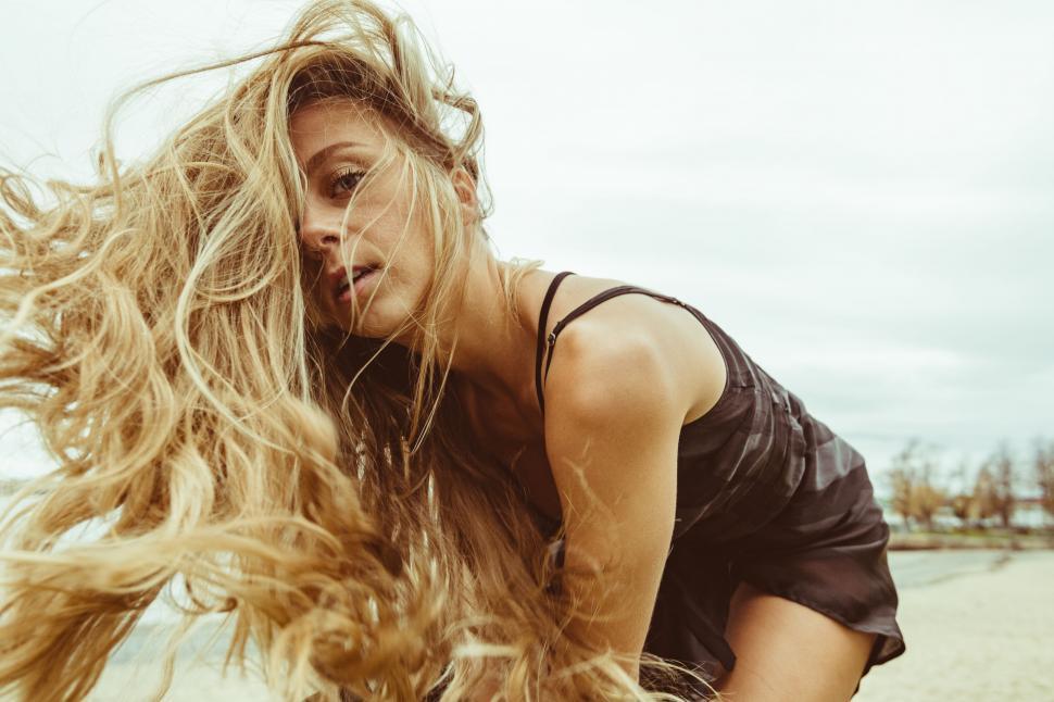 Free Image of Blond woman with hair billowing on beach 