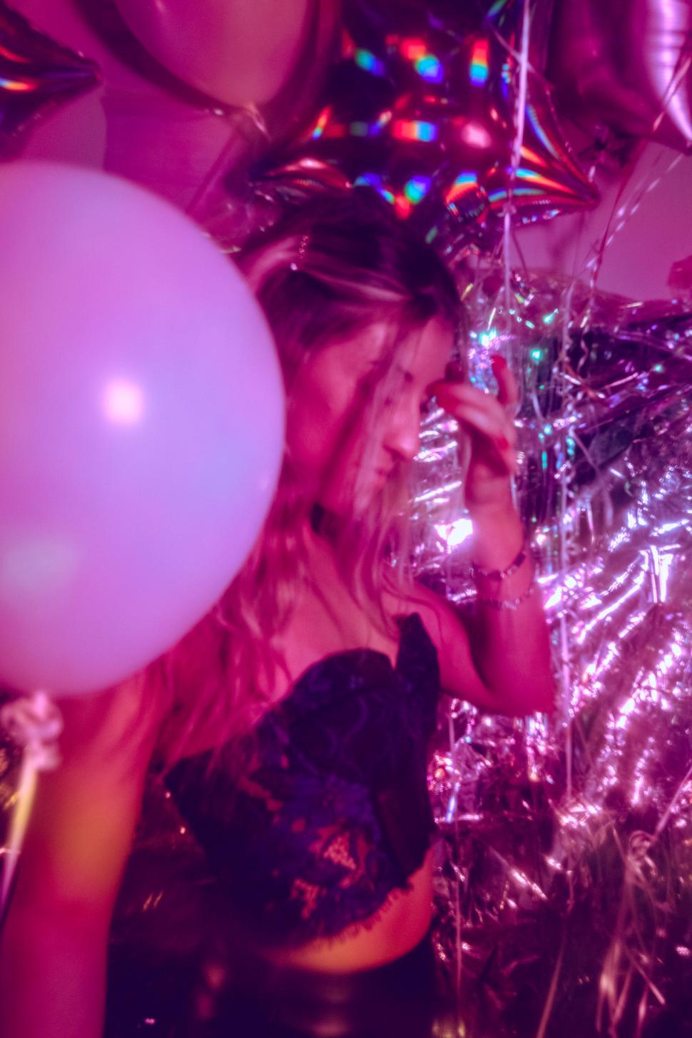 Free Image of Party girl surrounded by balloons and lights 