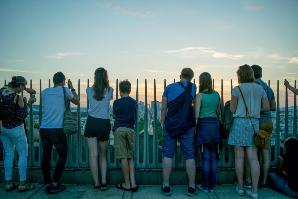 Free Image of Group of people watching sunset over city 