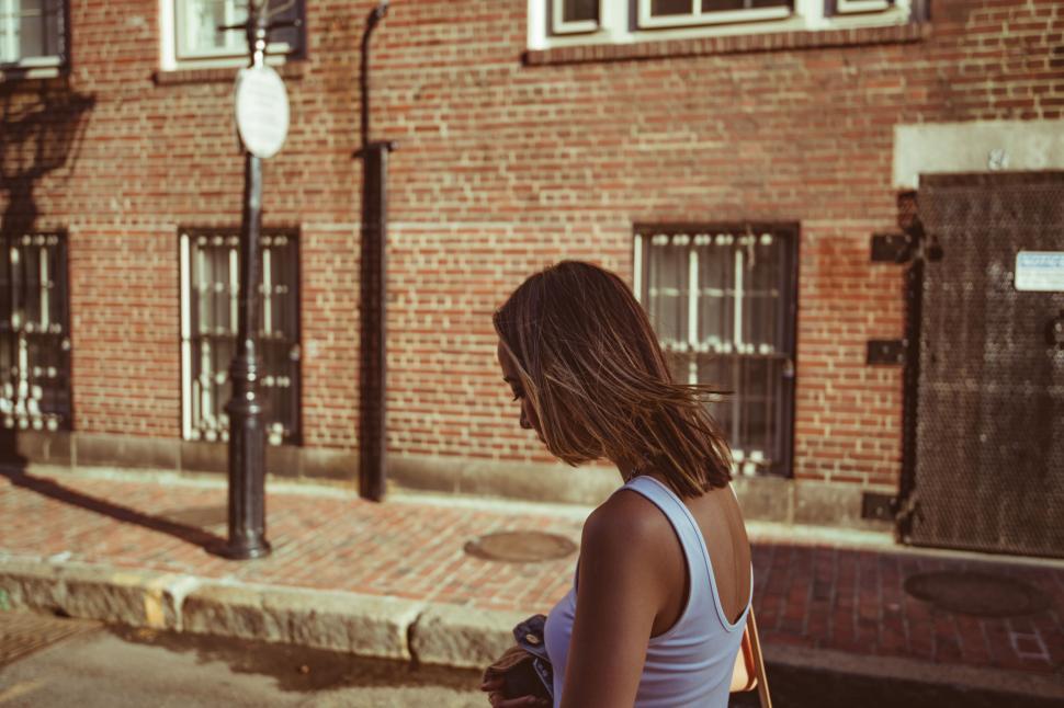 Free Image of Woman sitting on curb in urban setting 
