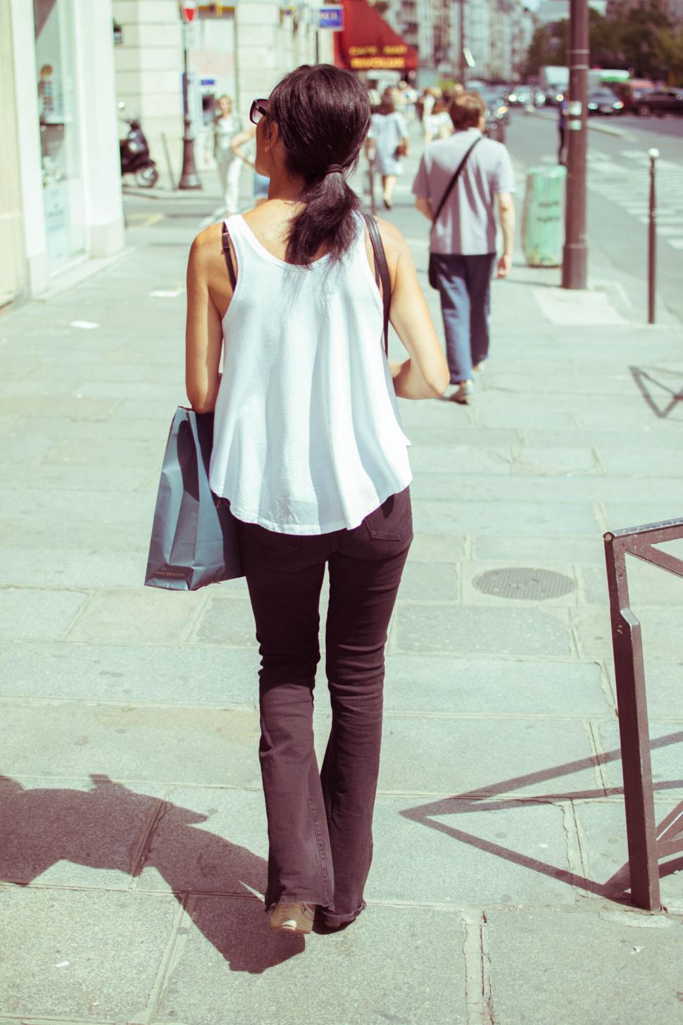 Free Image of Woman walking with shopping bag in city 