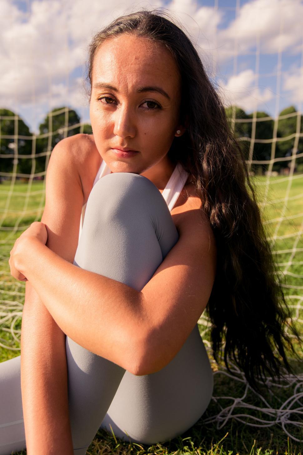Free Image of Athletic woman sitting on field 
