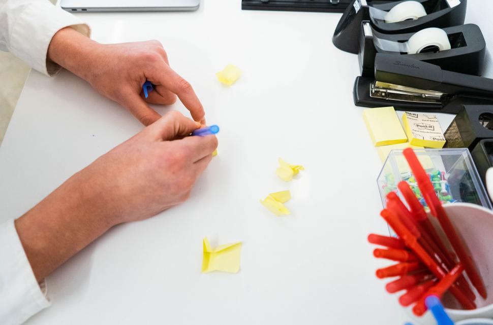 Free Image of Hands working with sticky notes on desk 