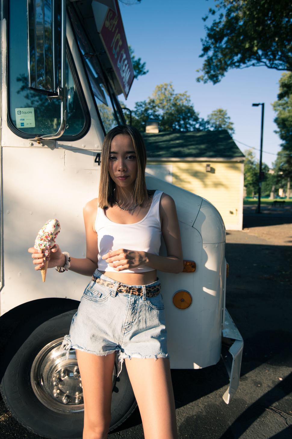 Free Image of Woman holding ice cream near vintage van 