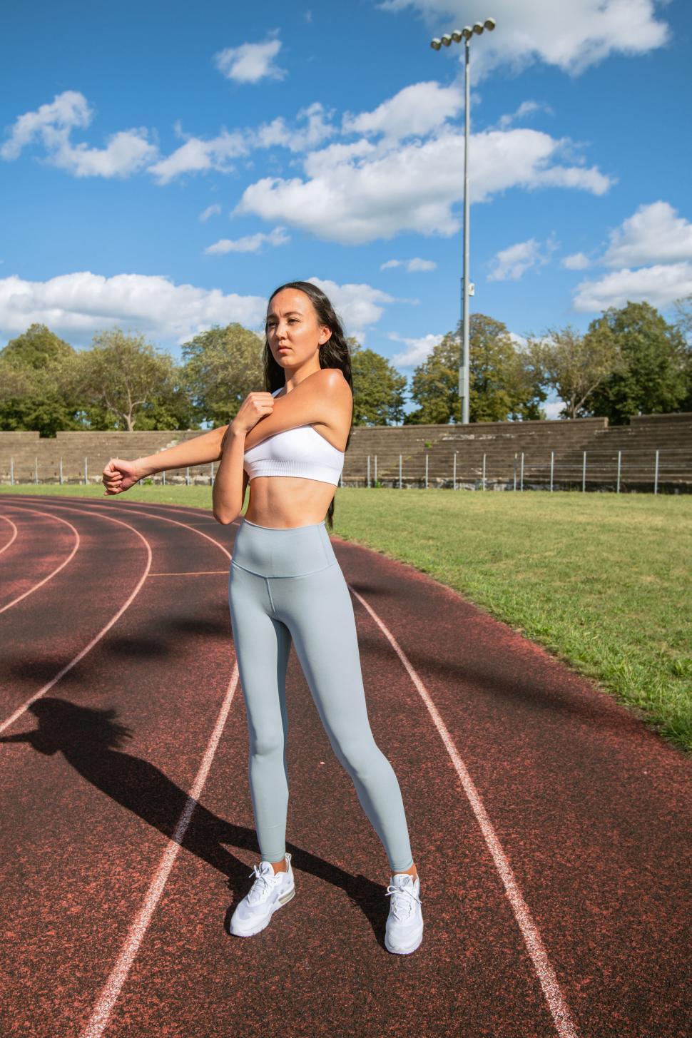 Free Image of Athletic woman stretching on a track field 