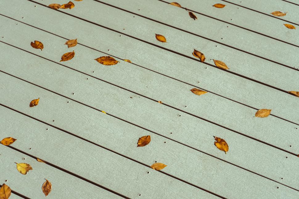 Free Image of Autumn leaves on a wooden walkway 