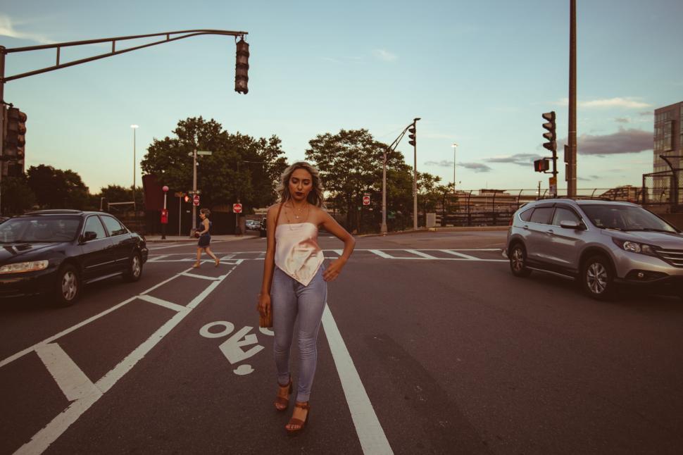 Free Image of Woman standing in middle of city intersection 