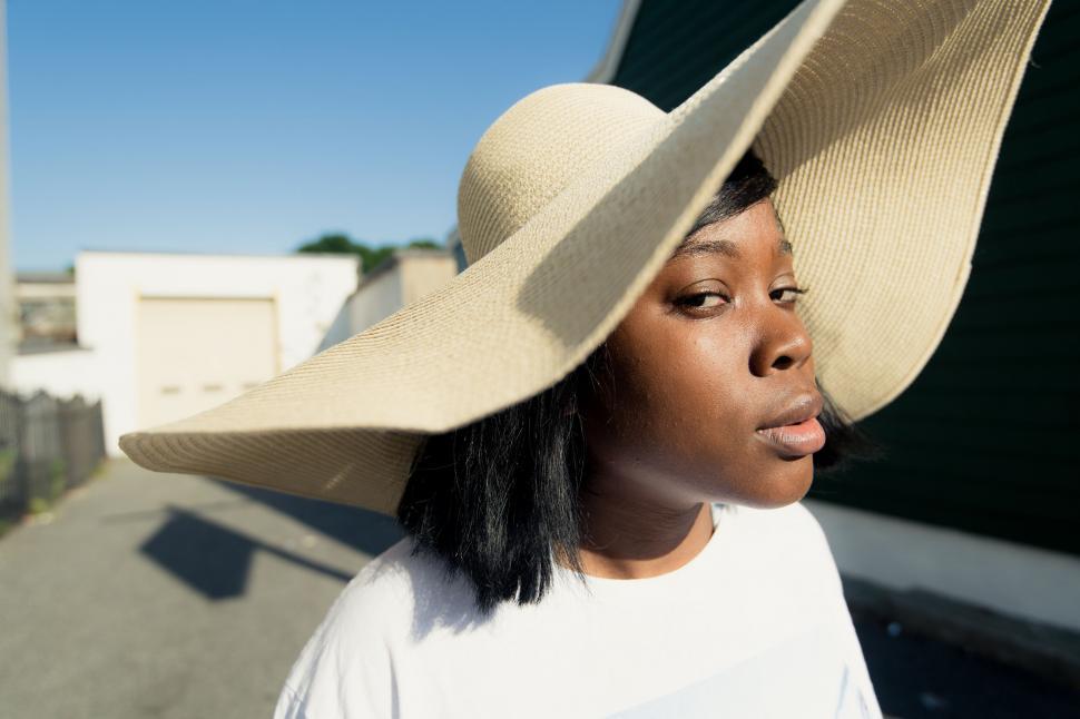 Free Image of Woman glamorously posing in an oversized hat 