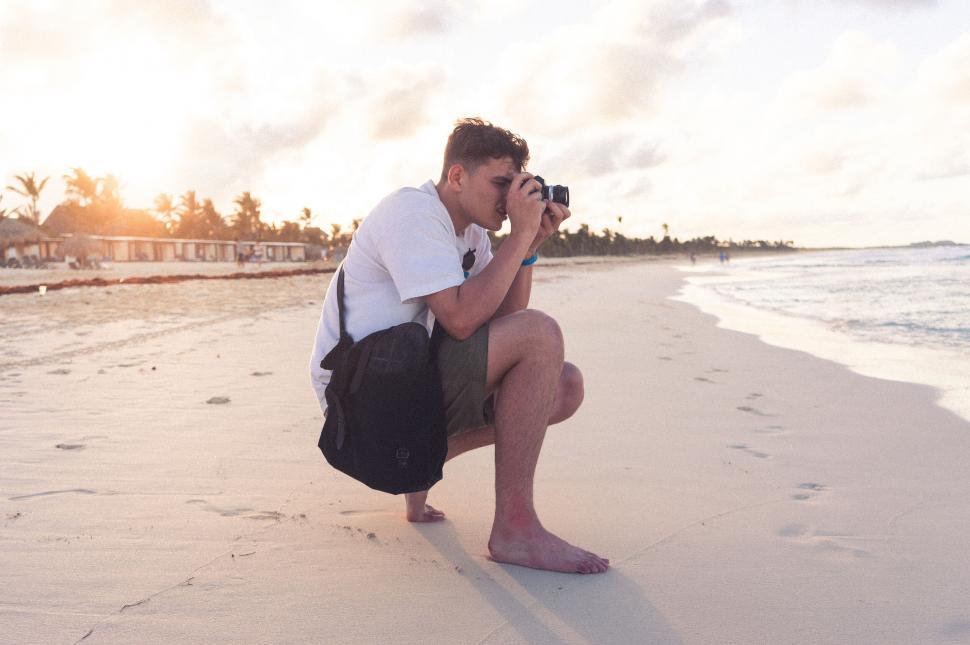 Free Image of Photographer capturing the beach at sunset 
