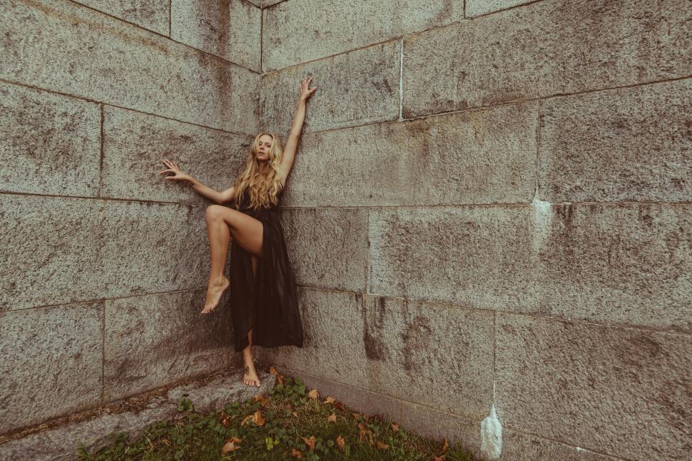 Free Image of Dynamic pose of woman against concrete 