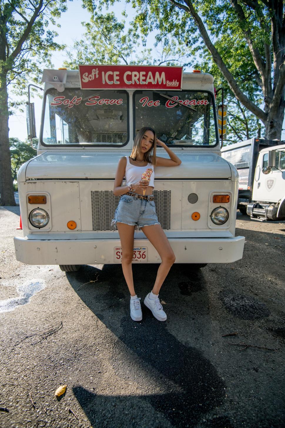Free Image of Woman with ice cream truck in the background 