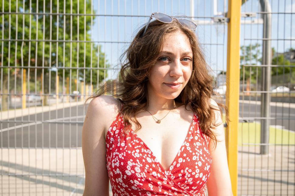 Free Image of Portrait of woman with chain-link fence 