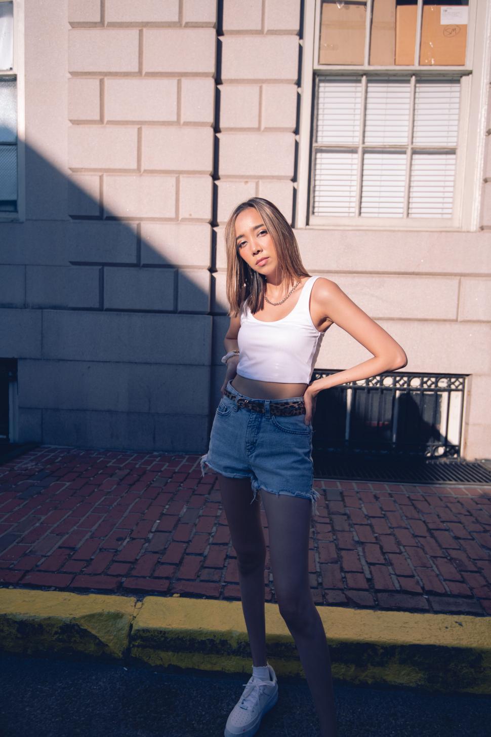 Free Image of Fashionable girl in sunlight on street 