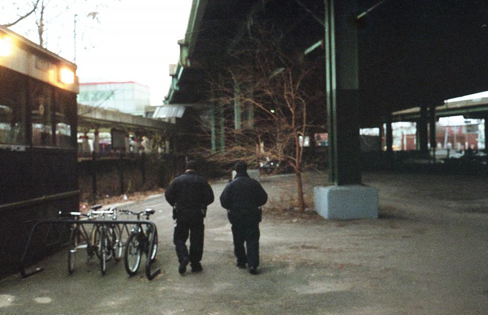 Free Image of Two people walking by the train station 