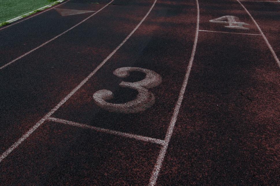 Free Image of Empty running track lanes with numbers 3 and 4 