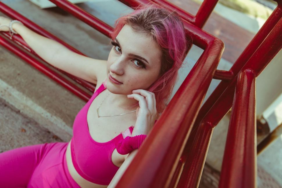 Free Image of Pink themed portrait of woman on fire escape 